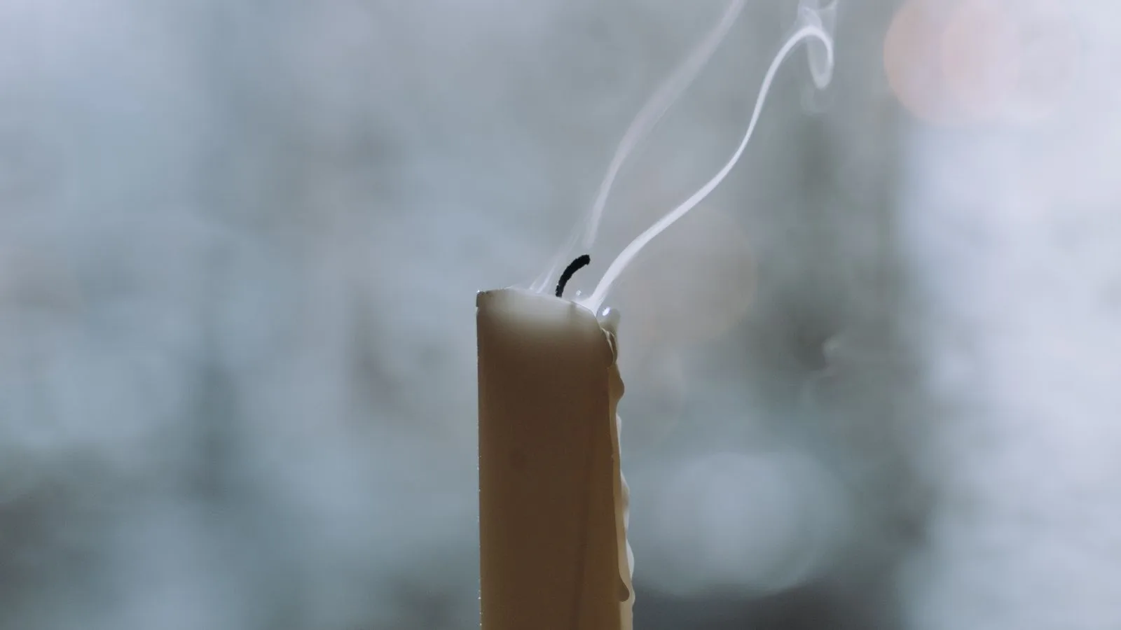Una vela recién apagada con el hilo de humo todavía subiendo