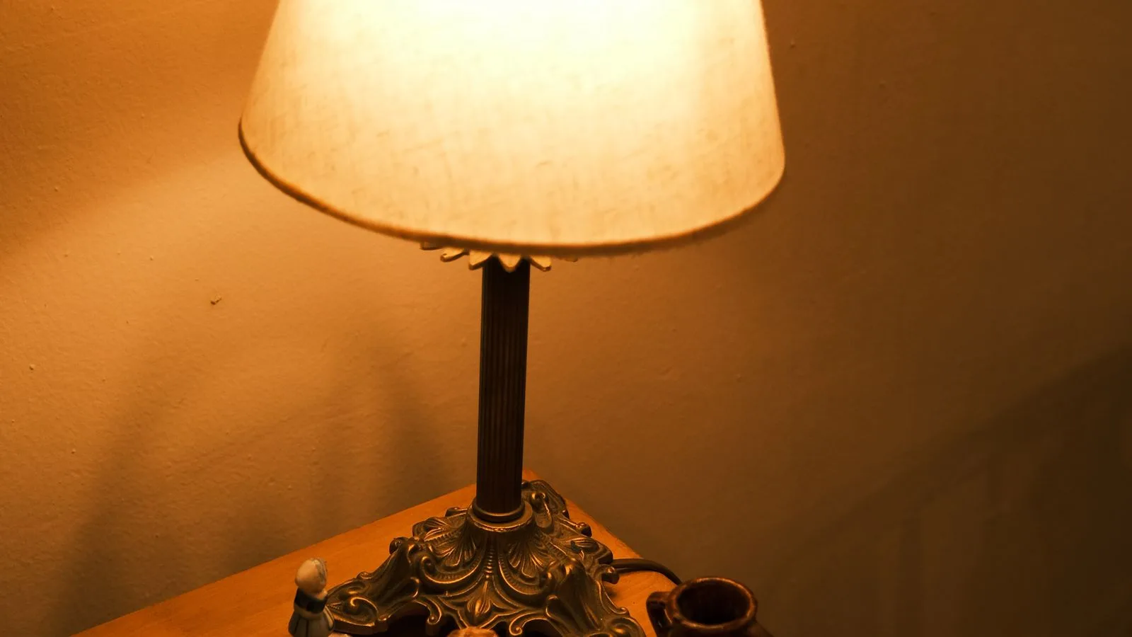 Una lámpara de mesita encendida en una habitación a oscuras