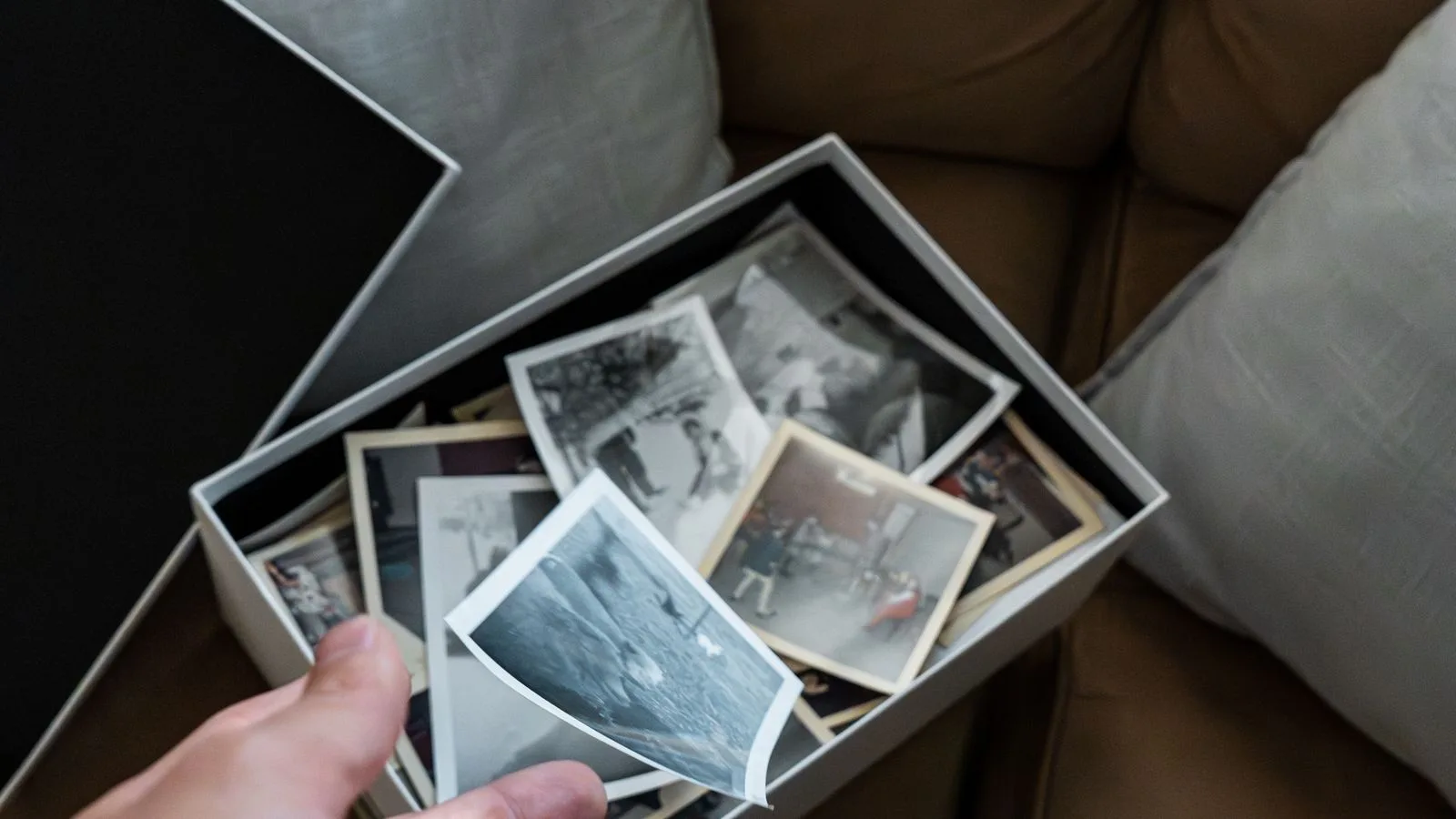 Unas manos sosteniendo un puñado de fotografías antiguas