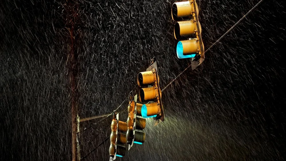 Un semáforo encendido de noche bajo la lluvia