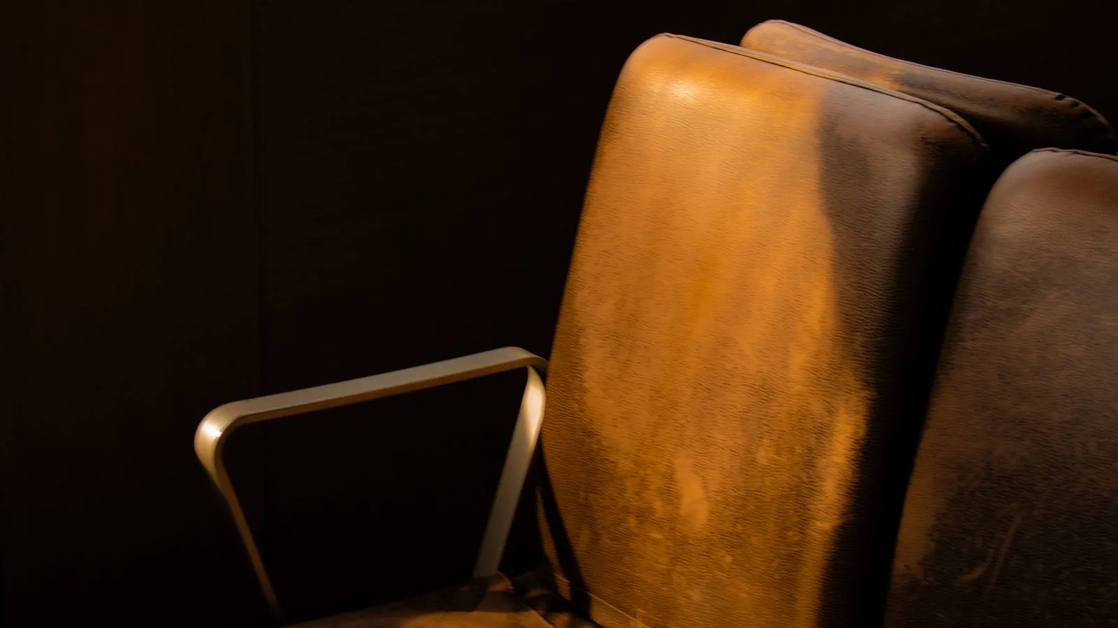 Un sillón vacío en una habitación en penumbra