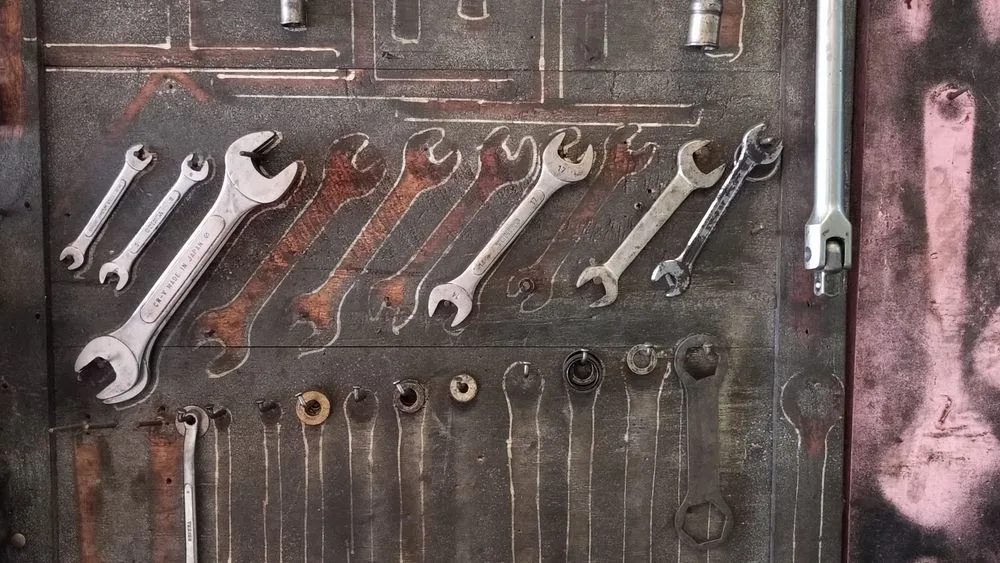 Un panel de taller con la silueta pintada de cada herramienta y varios huecos vacíos