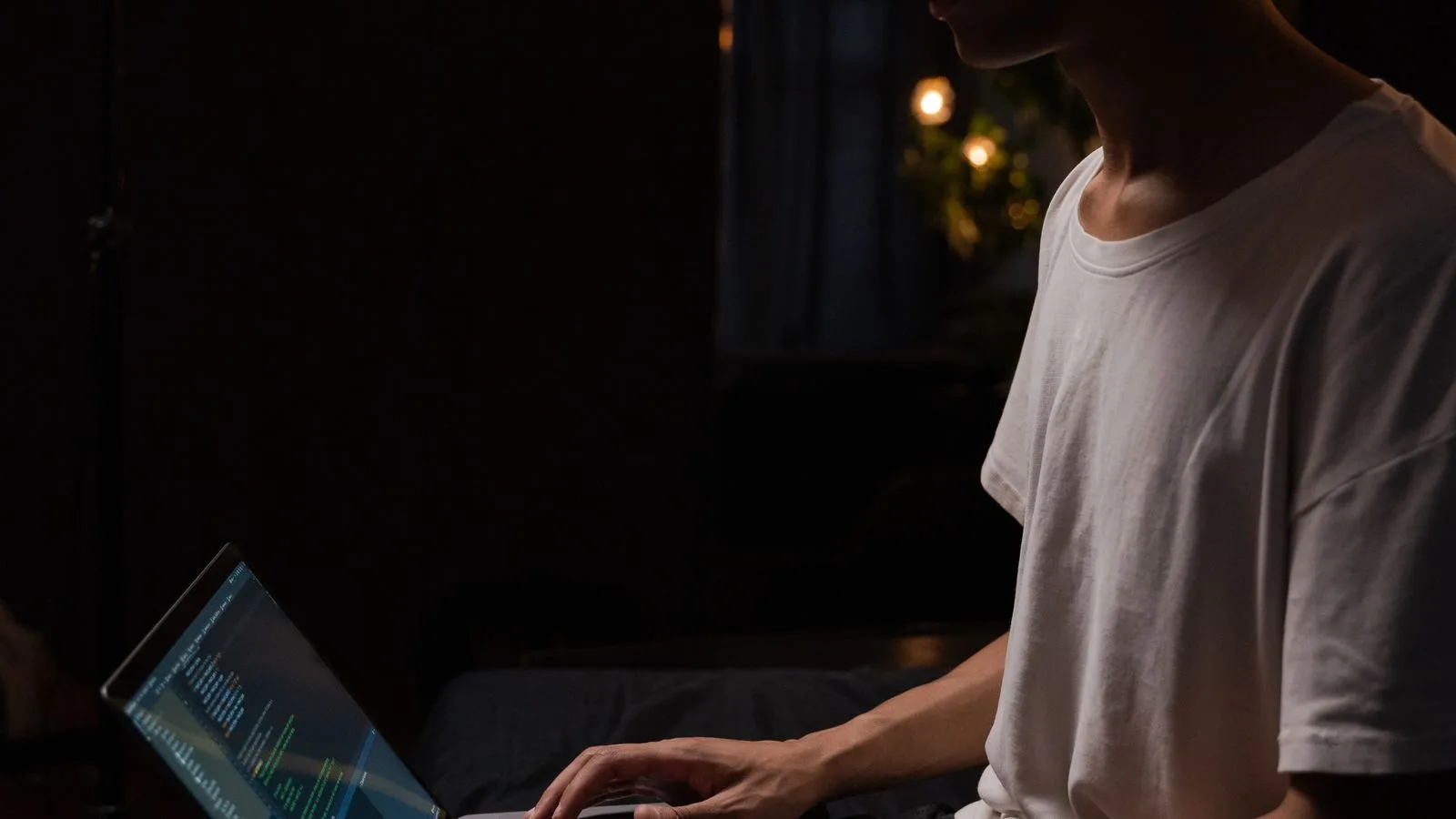Una persona trabajando de noche frente a la computadora en casa