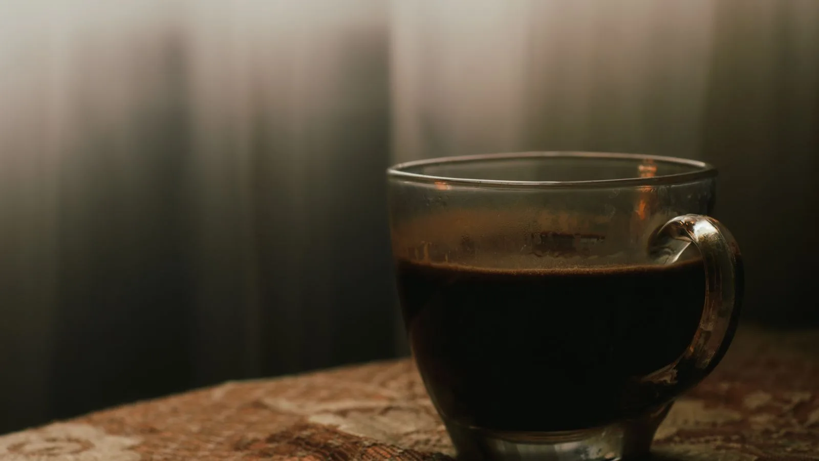 Una taza de café sobre una mesa de madera oscura
