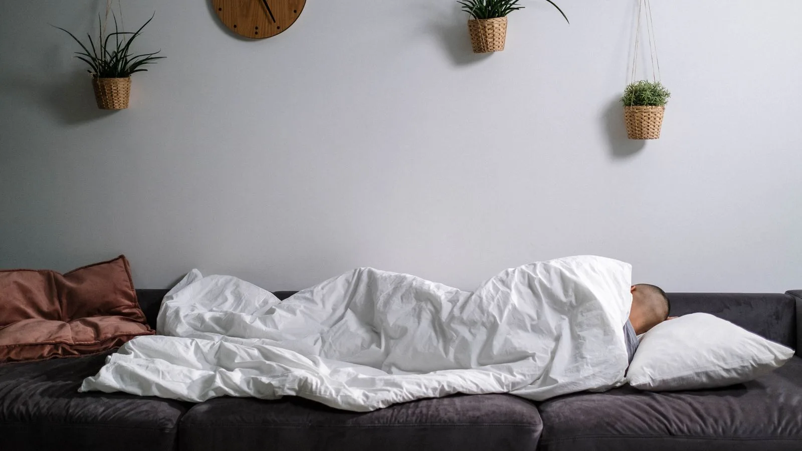 Una cama deshecha en una habitación con muy poca luz