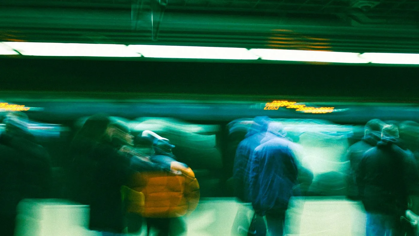 Personas caminando con movimiento borroso en una estación de metro oscura