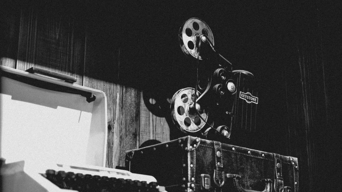 Una máquina de escribir de época en blanco y negro, sobre un escritorio de madera