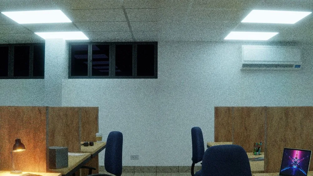 Una oficina vacía en penumbra, con escritorios y cubículos apenas iluminados