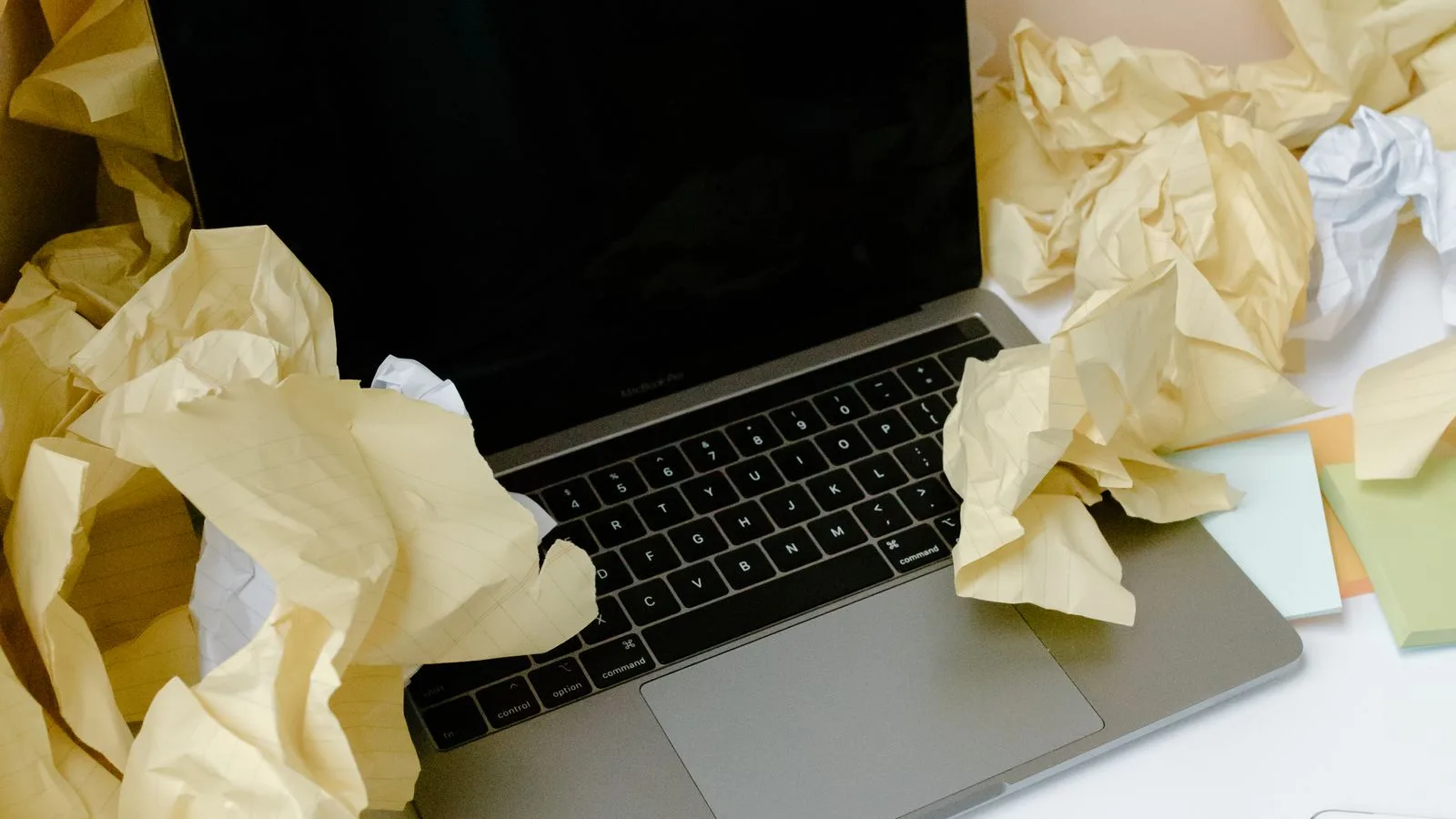Papeles arrugados amontonados alrededor de una computadora